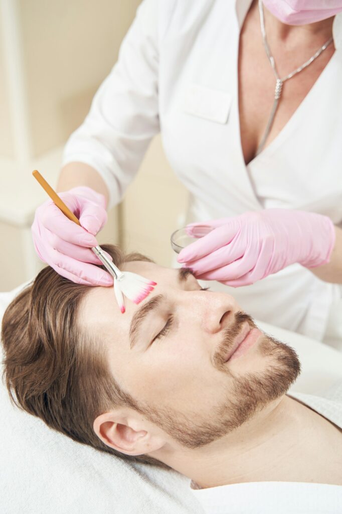 Application d'un peeling chimique sur le visage d'un homme – Medesthétique
